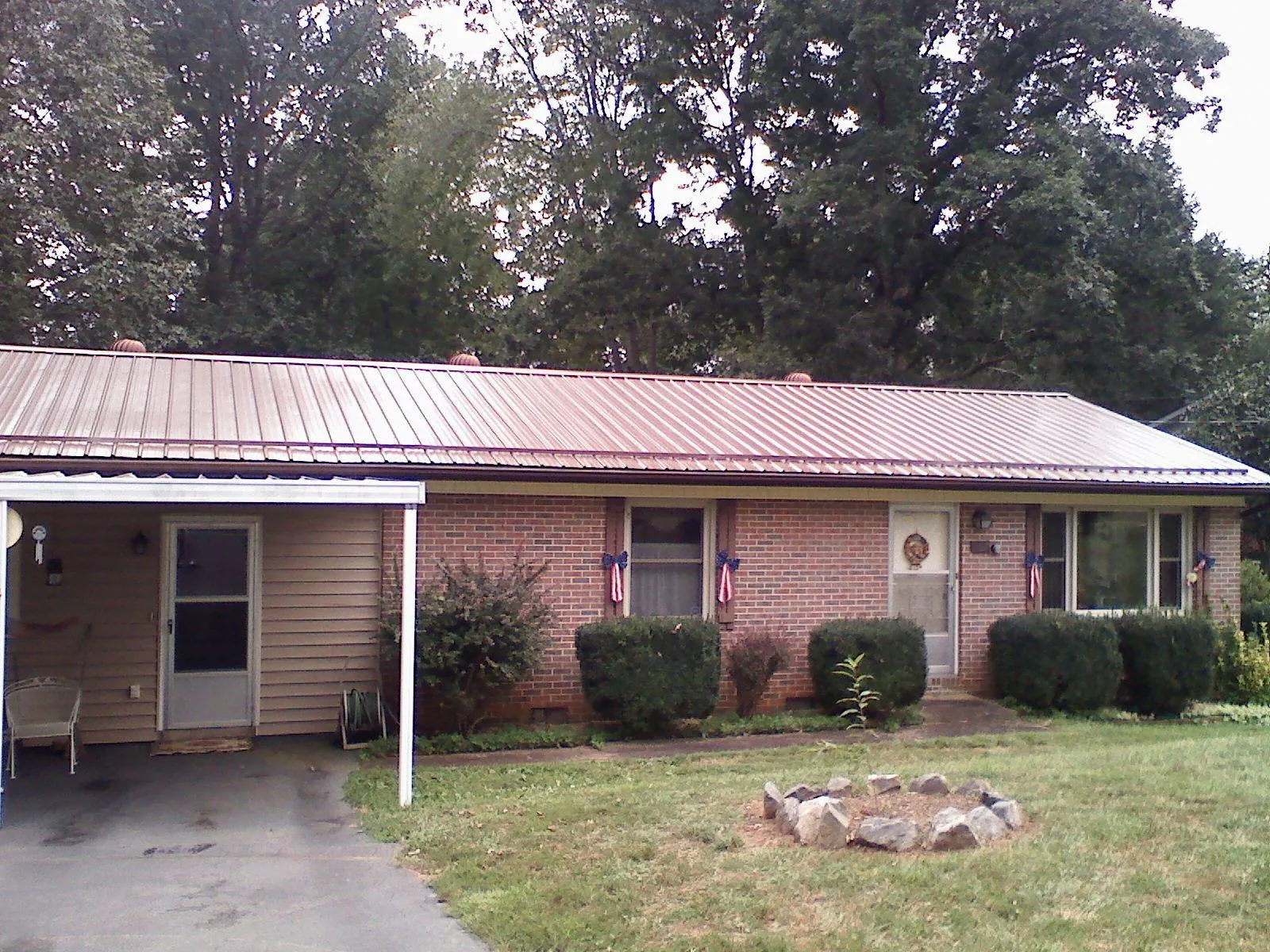 Bronze metal roof and carport on a brick ranch home — Roof Repair work by our crew in Concrete